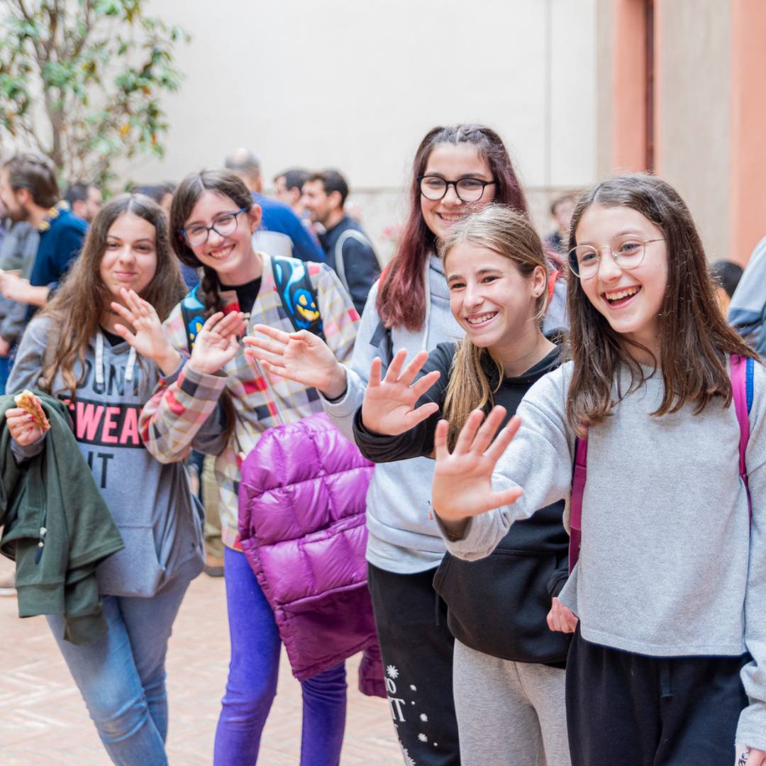 Grup d'alumnes que saluden a càmera.